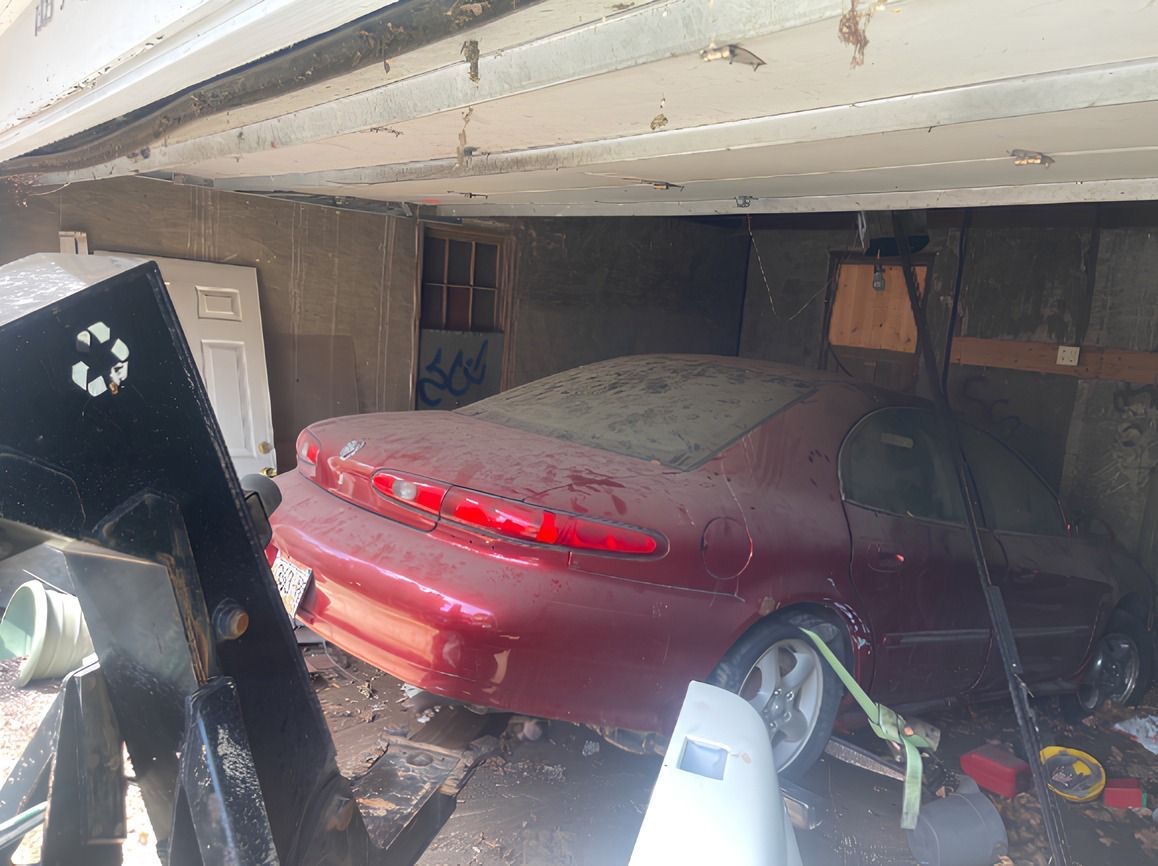 KMK winching a red junk car out of a cluttered Milwaukee garage